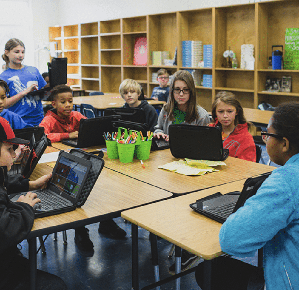 Students sitting at their desks working together on their computers